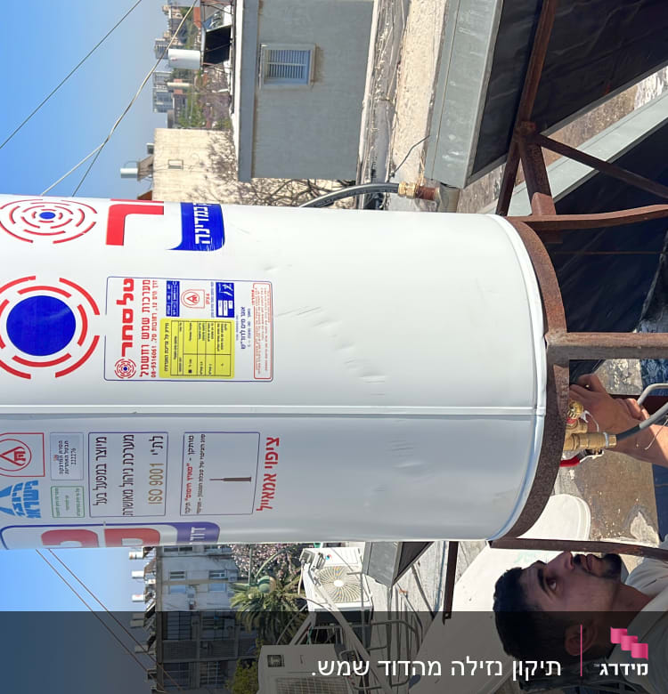 אדם מתקין דוד שמש על גג עם צינורות וחיבורים